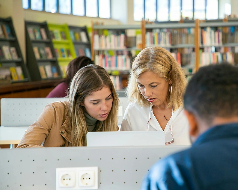 Student getting guidance from expert study abroad consultants in Kochi at a library workspace